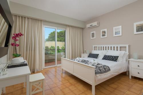 a bedroom with a white bed and a window at Melita City Apartment in Rhodes Town
