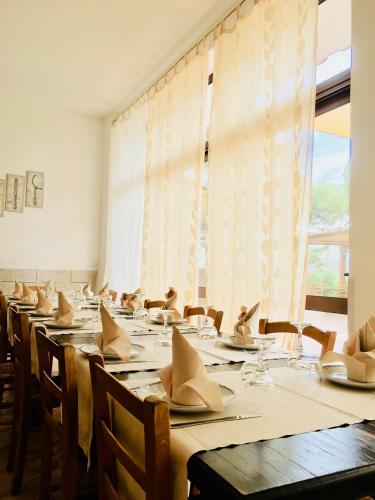 a dining room with tables and chairs with napkins on them at Affittacamere la Medusa in Porto Pino