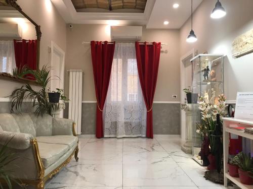 een woonkamer met rode gordijnen en een bank bij Ann Inn in Rome