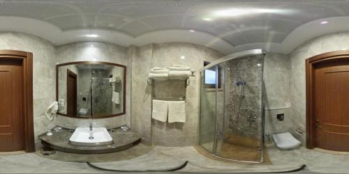 a bathroom with a shower and a sink at Hotel Milestone1915 in Gelibolu
