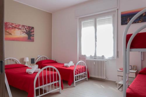 2 camas en un dormitorio con sábanas rojas en Grossi Apartment, en Rho