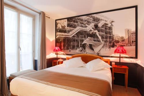 1 dormitorio con 1 cama con una foto en la pared en Hotel Atelier Vavin, en París