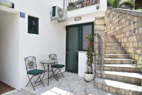 a patio with two chairs and a table next to a door at Klaris Guest house in Budva