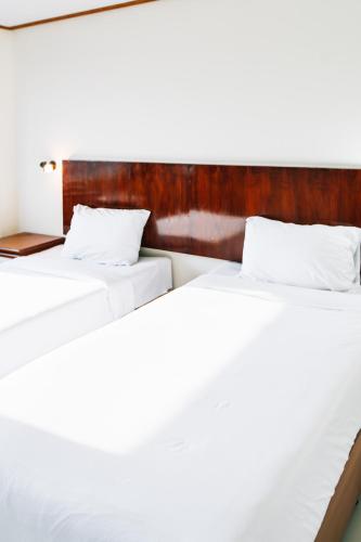 two beds sitting next to each other in a room at Sinkiat Thani Hotel in Satun
