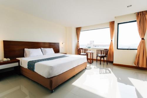 a hotel room with a bed and a table at Sinkiat Thani Hotel in Satun