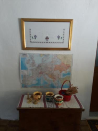 a table with three cups on it with a picture on the wall at Eco Garten Guest House in Shkodër