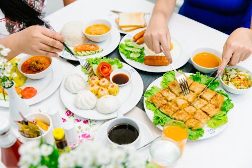 a table with plates of food on it at Sinkiat Thani Hotel in Satun