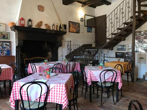 a restaurant with tables and chairs with red and white tablecloths at Civita B&B in Bagnoregio