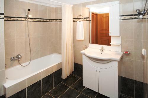 a bathroom with a sink and a bath tub and a toilet at Mari-Christi Apartments in Poros