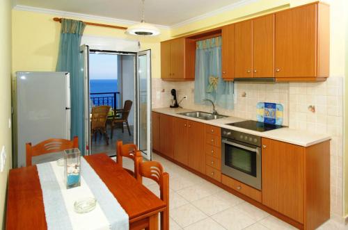 a kitchen with a table and a dining room at Mari-Christi Apartments in Póros Kefalonias