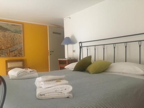 sypialnia z 2 ręcznikami na łóżku w obiekcie Suite Manzoni w Rzymie