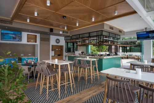 アギア・マリーナ・ネア・キドニアスにあるAtrion Resort Hotelのテーブルと椅子のあるレストラン、バー