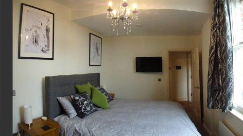1 dormitorio con cama y lámpara de araña en Hunter’s Retreat en York