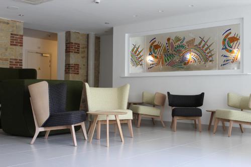 a row of chairs and tables in a waiting room at Hôtel Ginkgo - SPA Biloba in Quimper