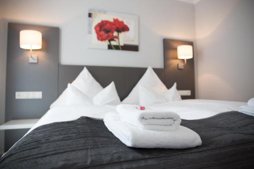 a bedroom with a bed with towels on it at ApartHotel "Am Fließ" in Hoyerswerda