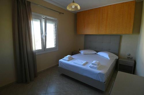 a bedroom with a large bed with a window at Pan Mare in Skala Sotiros