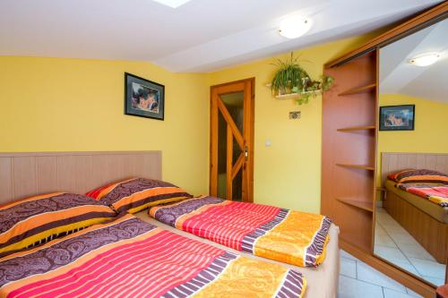 a bedroom with a bed and yellow walls at Penzion U Třeboňského kola in Třeboň