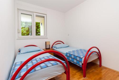 two beds in a room with a window at • Lungomare Beach Apartment Pula • in Pula