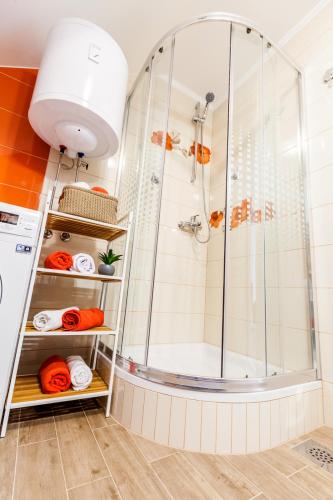 a shower in a bathroom with orange and white at Apartments MB in Kaštela