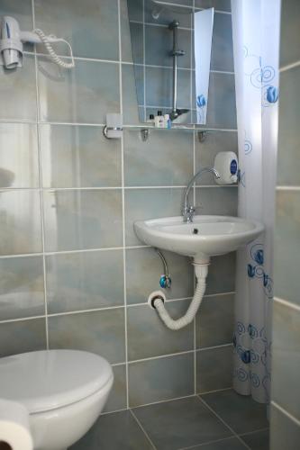 a bathroom with a sink and a toilet at Tunc Hotel in Ayvalık