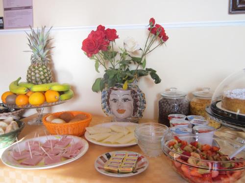 a table topped with plates of food and fruit at B&B BOUTIQUE DI CHARME "ETNA-RELAX-NATURA" in Zafferana Etnea