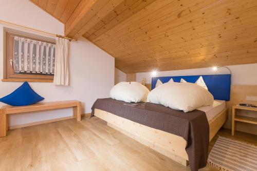 a bedroom with a bed with two pillows on it at Gasserhof Garni & Apartment in Schenna
