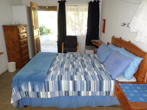 a bedroom with a bed and a dresser and a window at Geckos B&B and Self-catering in Coffee Bay