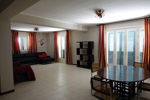 ein Wohnzimmer mit Tisch und Couch in der Unterkunft Villa Marianna in Santa Venerina
