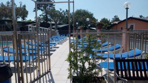 a row of lounge chairs sitting next to a pool at La Pineta in Albenga