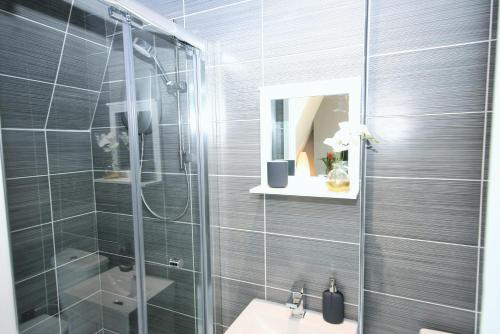 a bathroom with a shower and a sink and a mirror at Brick Lane Guest House in London