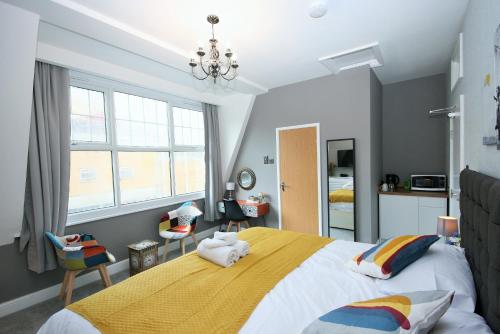 a bedroom with a large bed with a yellow blanket at Brick Lane Guest House in London