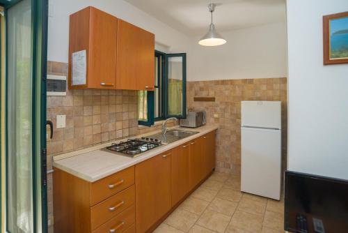 a kitchen with a sink and a white refrigerator at ARBI case vacanze in Mattinata