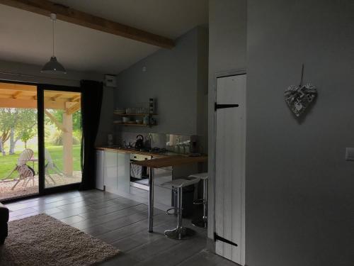 a kitchen with a counter and a table in a room at La Porcherie in Saint-Sernin