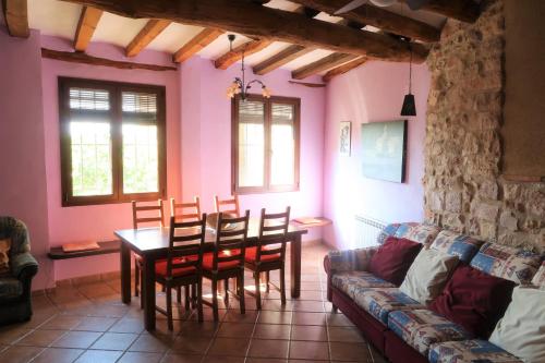 een woonkamer met een tafel en stoelen en een bank bij Casa Celestino in Alquézar