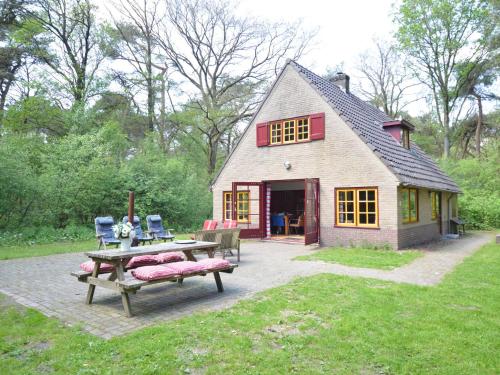 una pequeña casa con una mesa de picnic y una mesa de picnic Sidx Sidx en Detached holiday home surrounded by nature, en Zuidwolde