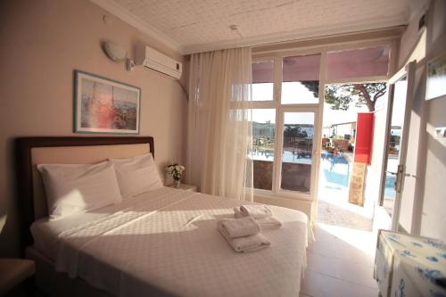 a bedroom with a bed with a towel on it at Tunc Hotel in Ayvalık