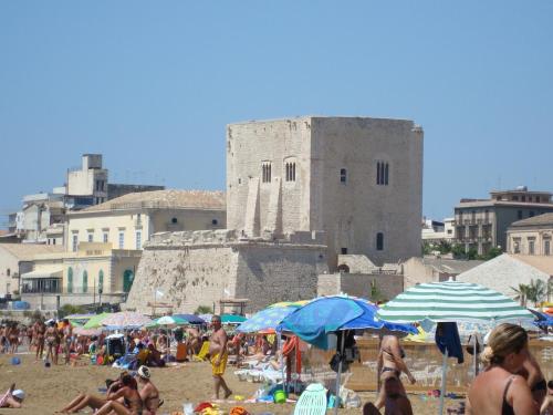 a group of people on a beach with umbrellas at fronte mare in Pozzallo