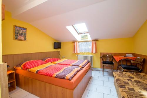 a bedroom with a bed and a desk and a table at Penzion U Třeboňského kola in Třeboň