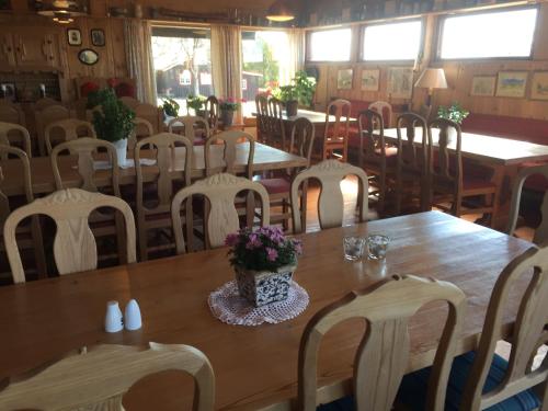 a dining room with tables and chairs and flowers on a table at Putten Seter in Høvringen