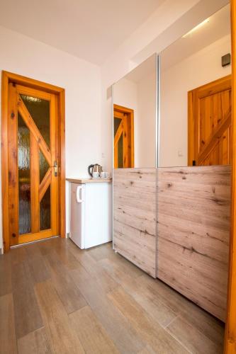 a large wooden pivot door in a kitchen with a refrigerator at Penzion U Třeboňského kola in Třeboň