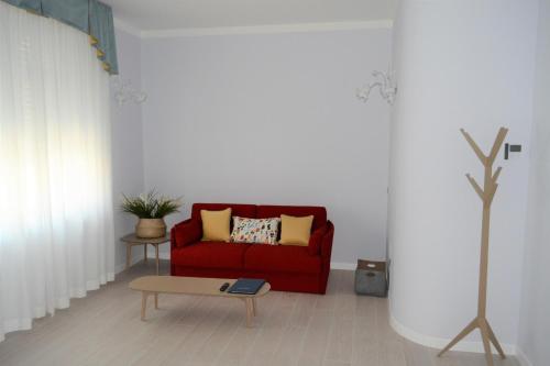 a living room with a red couch and a table at Les 7 Suites Erica in Grado