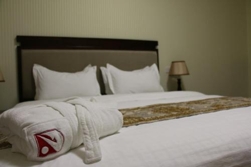 a hotel room with a bed with white sheets and pillows at Zargaron Plaza in Bukhara