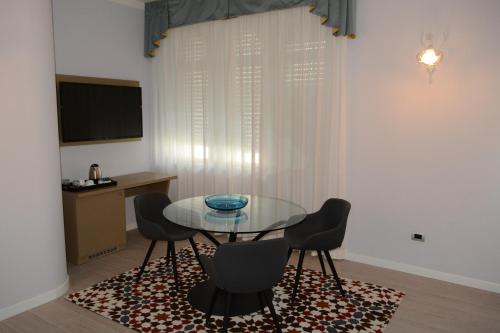 a dining room with a glass table and chairs at Les 7 Suites Erica in Grado