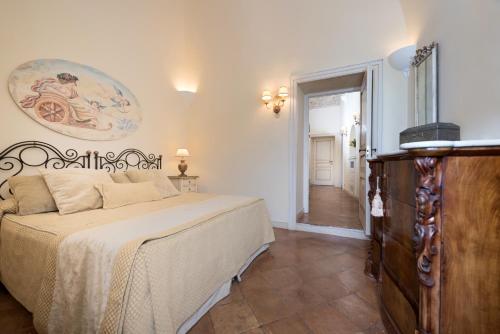 a bedroom with a bed and a dresser at Villa Alba d'Oro - Historic luxury villa in Amalfi
