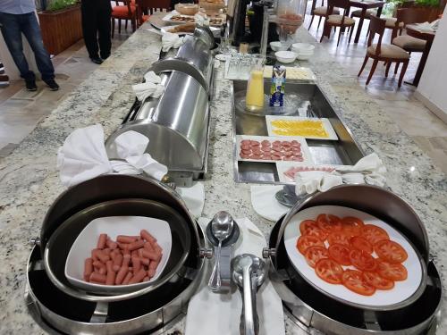 a buffet with two pans of food on a table at Gran Hotel De Lago - Lago Agrio in Nueva Loja