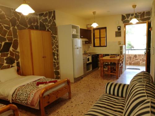 a living room with a couch and a kitchen at Apartments Zoumperi in Nea Makri