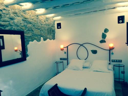 a bedroom with a bed with two lamps and a mirror at Hotel Galena Mas Comangau in Begur