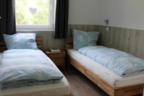 two beds in a room with a window at Haus Kornblume in Oberlangen