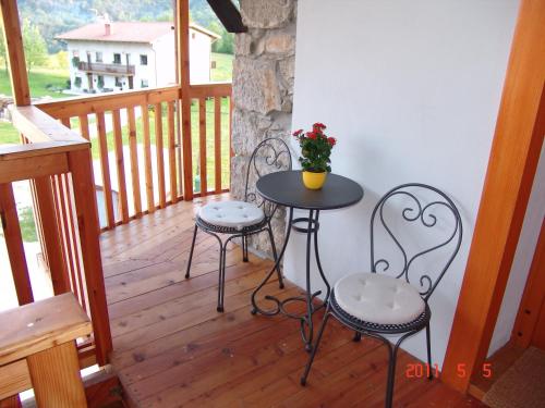 a porch with two chairs and a table on a balcony at Apartments Tonkli in Logje