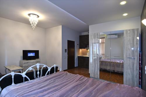 1 dormitorio con 1 cama grande y TV en Sayat Nova Apartment, en Ereván